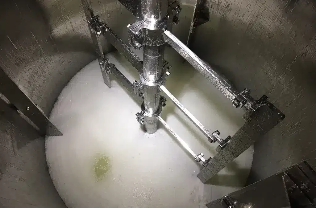 Vista interna de un depósito industrial con un agitador tipo áncora de AGITASER, fabricado en aleación resistente para procesos químicos corrosivos.