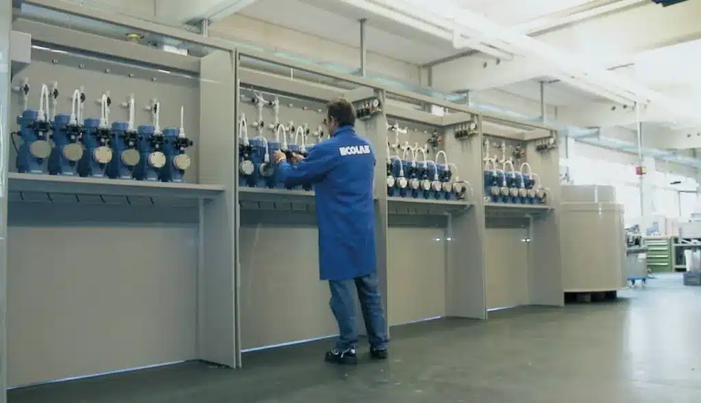 Operario ajustando bombas dosificadoras Ecolab en panel multicanal industrial