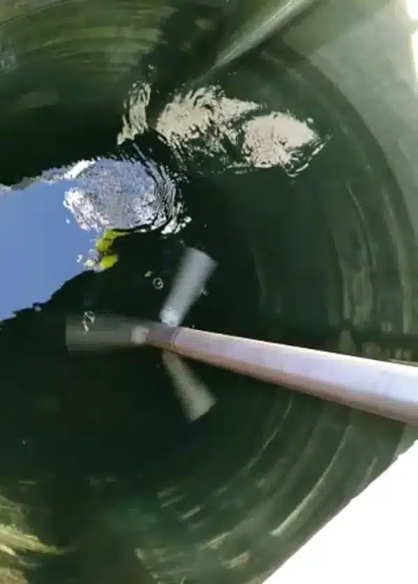 Agitador de floculación en funcionamiento generando un flujo laminar suave para promover la colisión de partículas sin turbulencia excesiva.